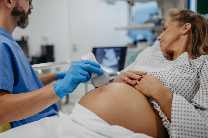 Ob/gyn doctor doing ultrasound of baby on pregnant woman.