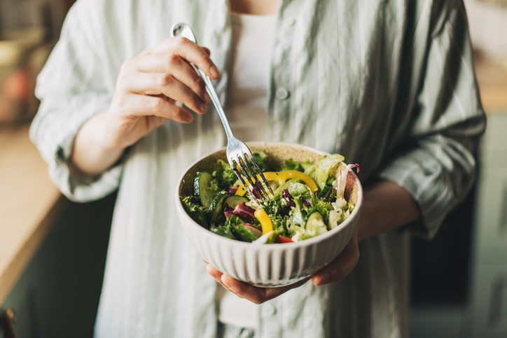 Woman holds bowl with a salad in it