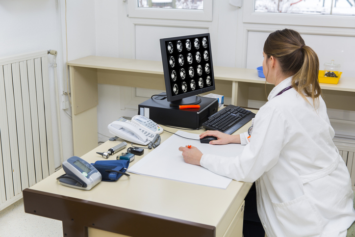 Photo shows doctor reviewing CAT scan of human abdomen