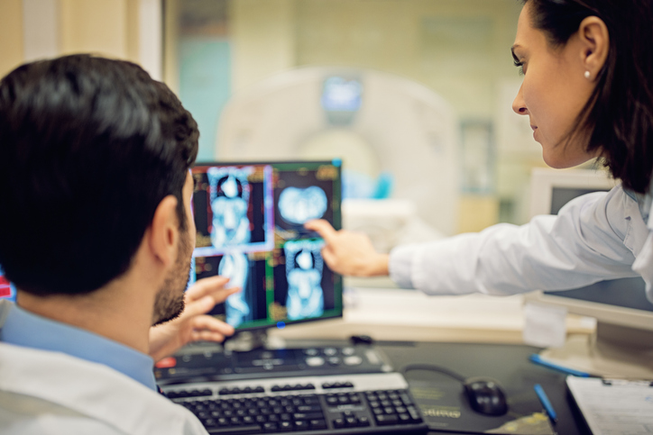 Photo shows doctors reviewing a CT scan in a hospital/Getty Images